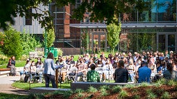 large group of students sitting in an amphitheater during a late August orientation