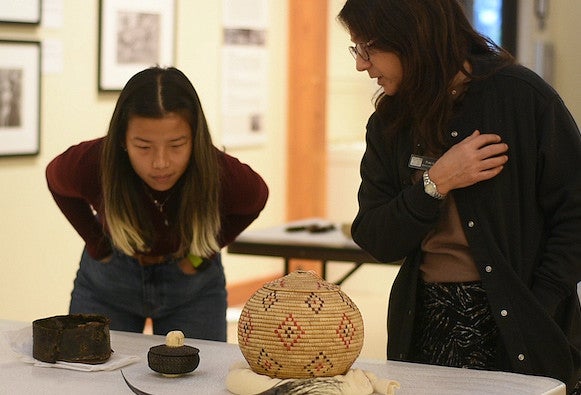 Two people examining three baskets on a table