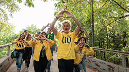 Students in yellow UO T-shrits 'throwing their O' on a bridge.