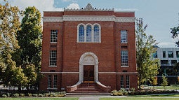 Chapman Hall seen from the west, surrounded by trees in late autumn.