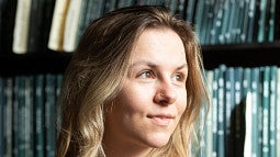 Lucy Roberts in front of a shelf full of theses.