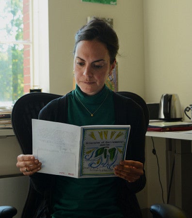 Catalina de Onís sitting in a high-backed chair and reading