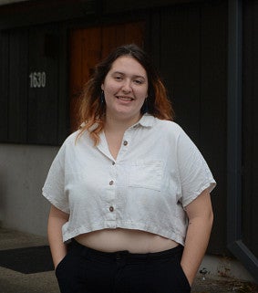 Marisol Peters standing in front of a dark building entrance cover
