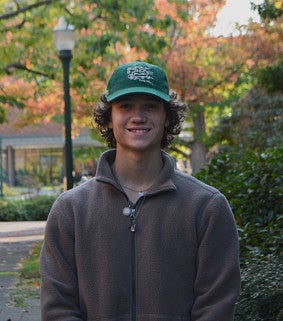 William Bird standing at a campus in autumn.