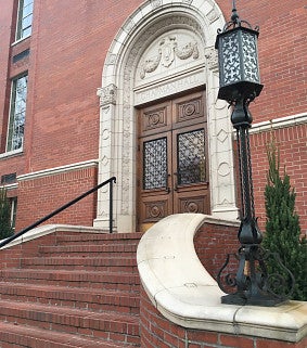 Western stone stair leading up to Chapman Hall's wooden door set in the red brick.