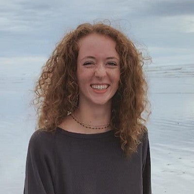 Mugshot of Amada Kurtz standing on the shore of a large body of water.